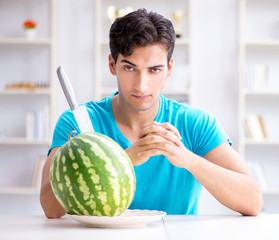 Fototapeta premium Man eating watermelon at home