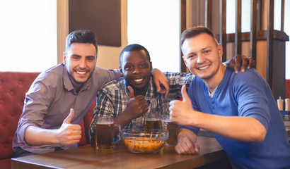 Cheerful friends taking photo with thumbs up at bar