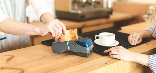lose up of paying with gold card in online terminal in cafe
