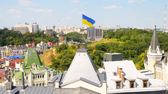 Kyiv, Ukraine cityscape skyline of Kiev and Ukrainian flag on roof waving in the wind during summer in Podil district