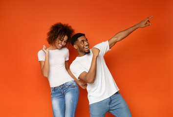 Positive african american man and woman dancing and laughing