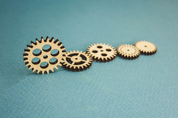 five wooden gears standing on a blue background