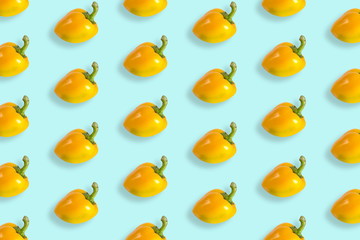 Composition of bell peppers. Pattern of yellow bell peppers on a pastel blue background. Flat lay, top view, copy space.