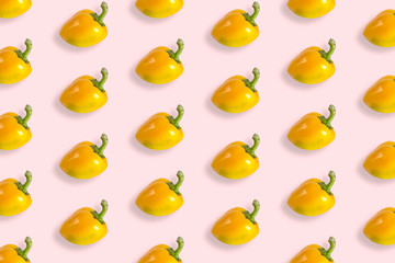 Composition of bell peppers. Pattern of yellow bell peppers on a pastel pink background. Flat lay, top view, copy space.