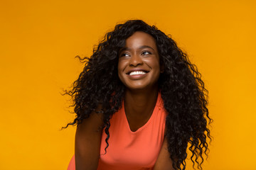 Excited african woman with wide smile looking aside