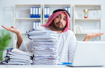 Arab businessman working in the office doing paperwork with a pi