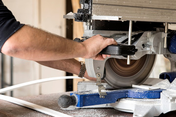 ouvrier en train de scier du plastique