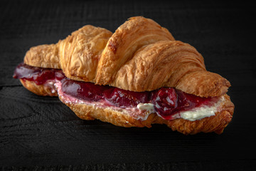 Croissant sandwich with butter and plum in own juice. Healthy, tasty, nourishing snack. Take away food