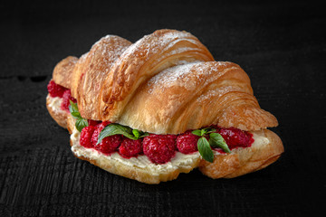 Croissant sandwich with raspberries in syrup and mint. Healthy, tasty, nourishing snack. Take away food