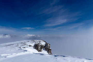 Fototapeta na wymiar Snowy mountains above the clouds