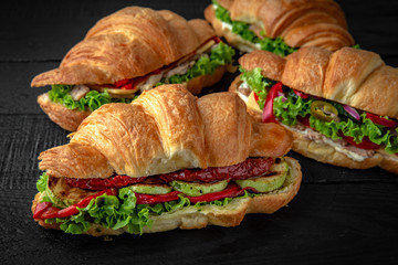 A lot of Croissants sandwich with boiled chicken, mushrooms, cheese, tomatoes, and different toppings. Healthy, tasty, nourishing snack. Take away food