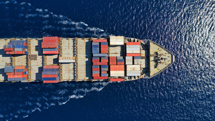 Aerial top down photo of large cargo container ship cruising the deep blue Mediterranean sea