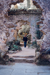 Man walking by some ruins