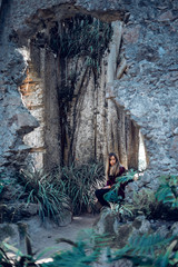 Woman sitting on the ruins of an antique church