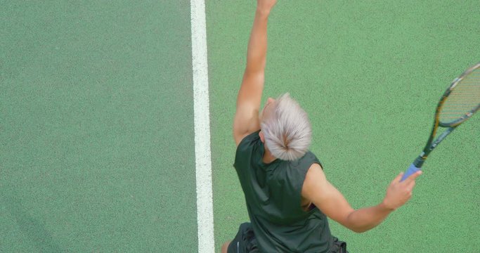 Close up of a mixed race platinum haired tennis player serving.