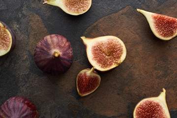 top view of ripe whole and cut tasty figs on stone background