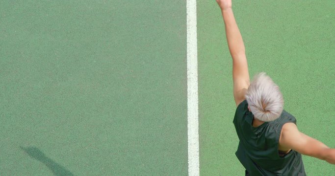 Close up of a mixed race platinum haired tennis player serving.