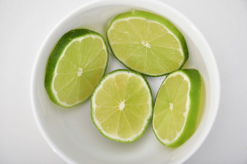 Fototapeta na wymiar Limón en rodajas en tazón y plato blanco