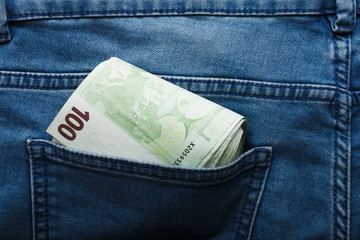 100 hundred euro banknotes on the beige background in jeans pocket top view with copy space. Money, business, finance, saving, banking concept, wealth, waste. Exchange Rates.