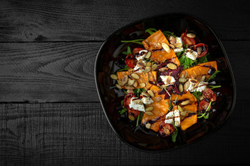 Diet vegetarian salad of grilled pumpkin, beets, tomatoes and seeds, baked pepper, arugula, feta cheese, balsamic sauce and oregano. Vegetable vitamin healthy, nutritious snack