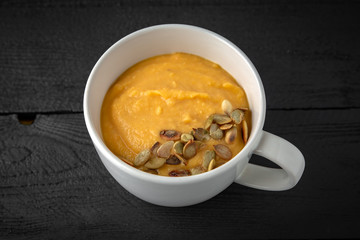 Cream soup made of pumpkin, spinach, broccoli and lentils with parmesan, pumpkin seeds and cream. Tasty, healthy nutritious lunch.