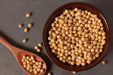 raw and fresh soy beans inside brown ceramic bowl on rustic wooden table..