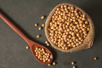 Fresh an raw soy beans in rustic fabric bag on gray background ..