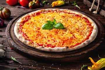 Tasty hot italian pizza Classic Margherita (Margarita) with Mozzarella Cheese, Tomato Sauce, Basil with  on old wooden table. Pizzeria menu. Concept poster for Restaurants or pizzerias