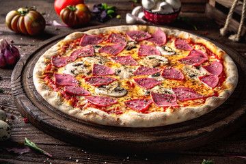 Tasty hot italian pizza Grand with Ham, Mushrooms, Cheddar Cheese, Oregano  on old wooden table. Pizzeria menu. Concept poster for Restaurants or pizzerias