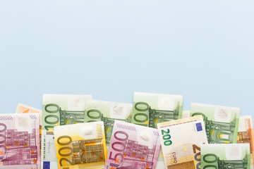 50, 100, 200, 500 euro banknotes on the blue background top view with copy space. Money, business, finance, saving, banking concept. Exchange Rates. Small business: interest rate reduction.