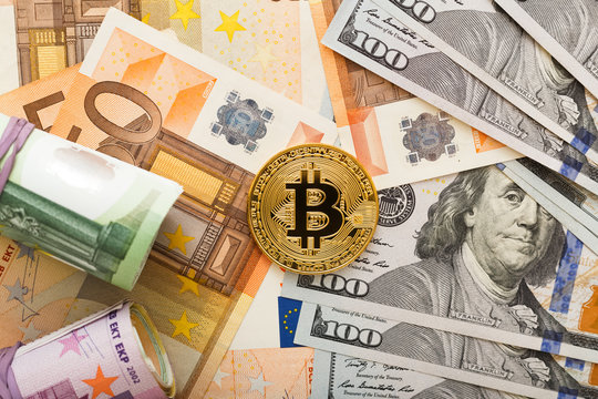 Golden bitcoins with dollars and euro banknotes as a background. Virtual crypto currency, digital concept.