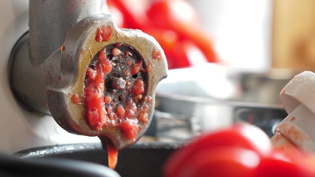 Process of cooking tomato sauce in meat grinder. Closeup at the kitchen