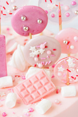 A slice of pale pink cake with marshmallows, candies.