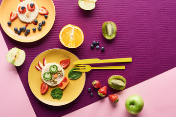 top view of plates with fancy animals made of food near fruits on purple background