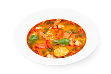 Closeup plate of traditional thai soup - tom yum kung isolated at white background.
