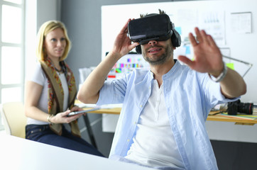 Young male software programmer testing a new app with 3d virtual reality glasses in office.