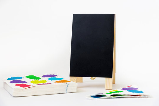 Napkin with color splashes and a blank white board for party invitations