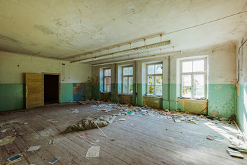 Old abandoned room with broken windows and broken furniture.