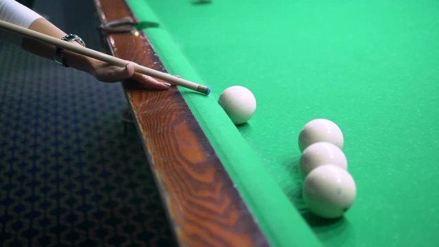 billiards. Close-up. man hand with cue and white ball on a green pool table. copy space