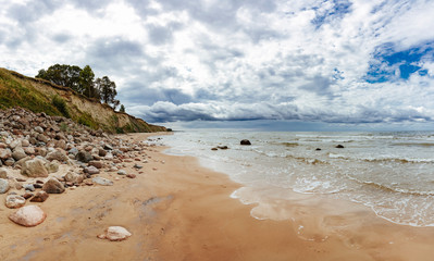 Rocky coast line of the Baltic sea in Latvia, during sunny summer day with blue sky.