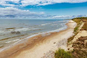 Fototapeta na wymiar Rocky coast line of the Baltic sea in Latvia, during sunny summer day with blue sky.