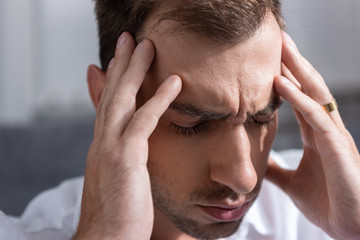 Fototapeta premium depressed man touching man with closed eyes at home