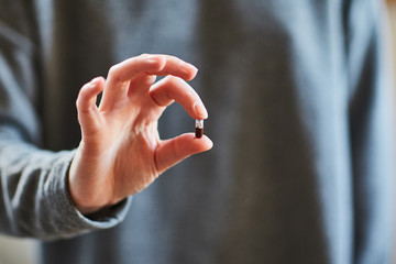 a young girl holds a tablet in her hands. Capsule in the hand. Medication. The medicine