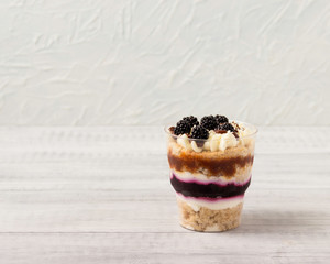 Delicious dessert in a glass, with blackberry jelly and caramel.