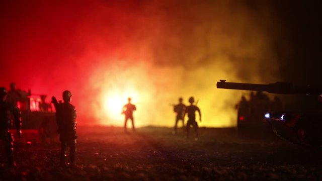 War Concept. Military silhouettes fighting scene on war foggy sky background at night. Armored vehicles with soldiers ready to attack. Artwork decoration. Selective focus