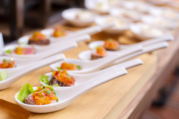 Ham pineapple sauce canape selection on wooden slate platter