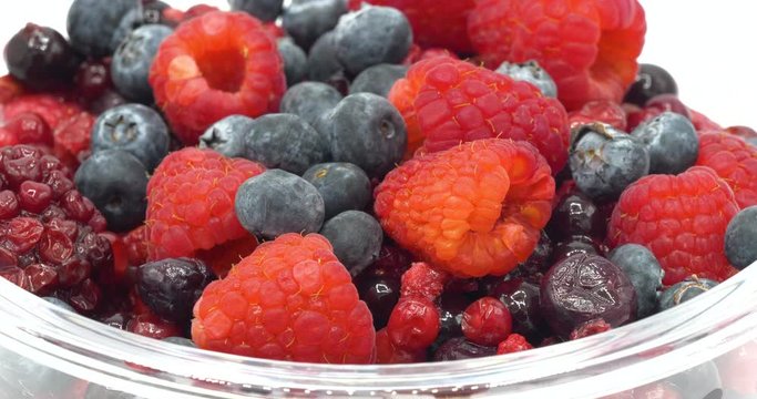 Various colourful berries in glass blow rotation on white background, strawberry, raspberry, blackberry, blueberry, healthy food concept.