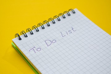 Blank yellow background with place for text.  Sketchbook, pen and cactus in a gray pot as a decoration. View from above. Flat lay, real photo. Minimal composition. Copy space