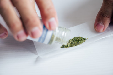 cropped view of man in t-shirt pouring out medical cannabis