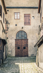 Fototapeta premium Old european wooden door down the alleyway